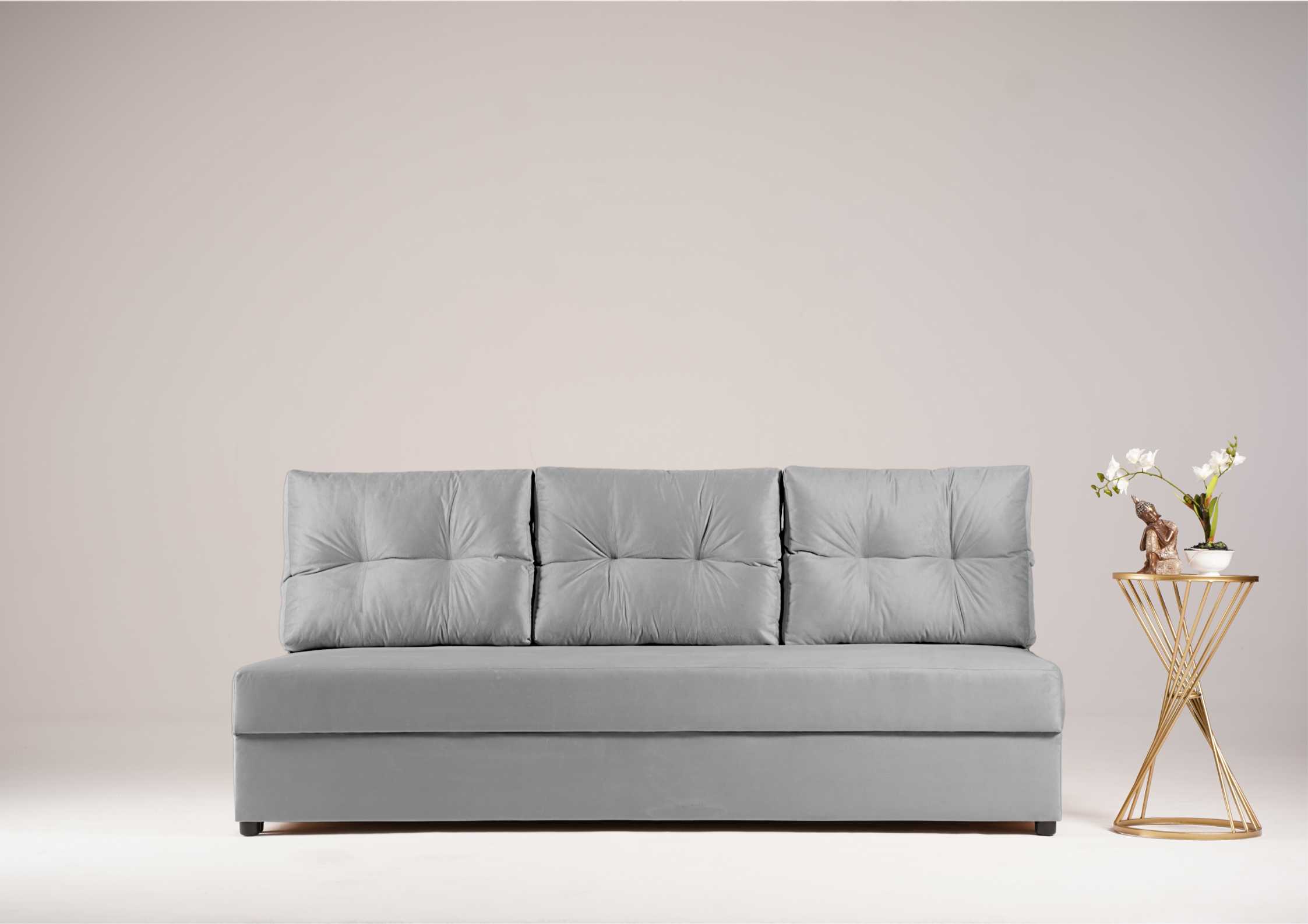 Szara sofa z pikowanymi poduszkami